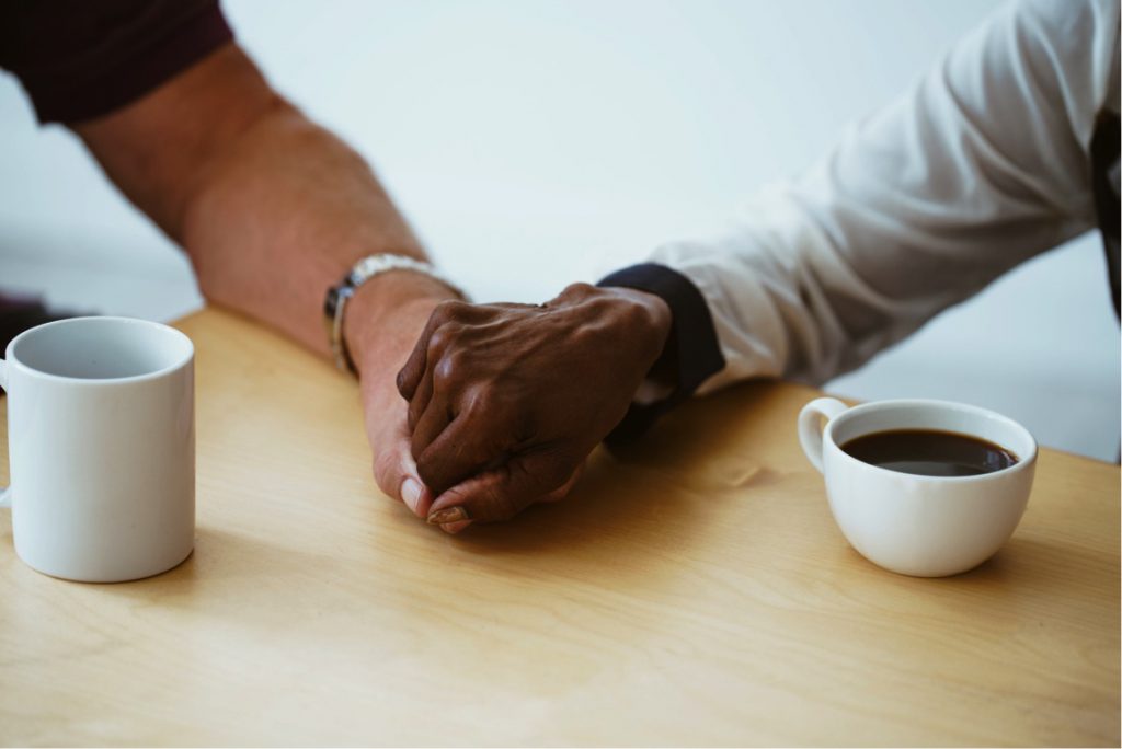 Holding hands while drinking coffee