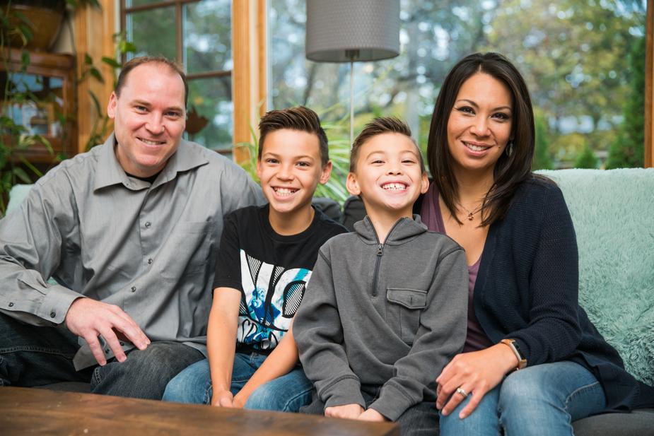 Family sits together on sofa