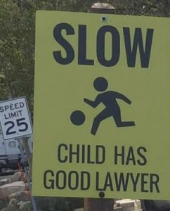 Street sign that says slow child has good lawyer