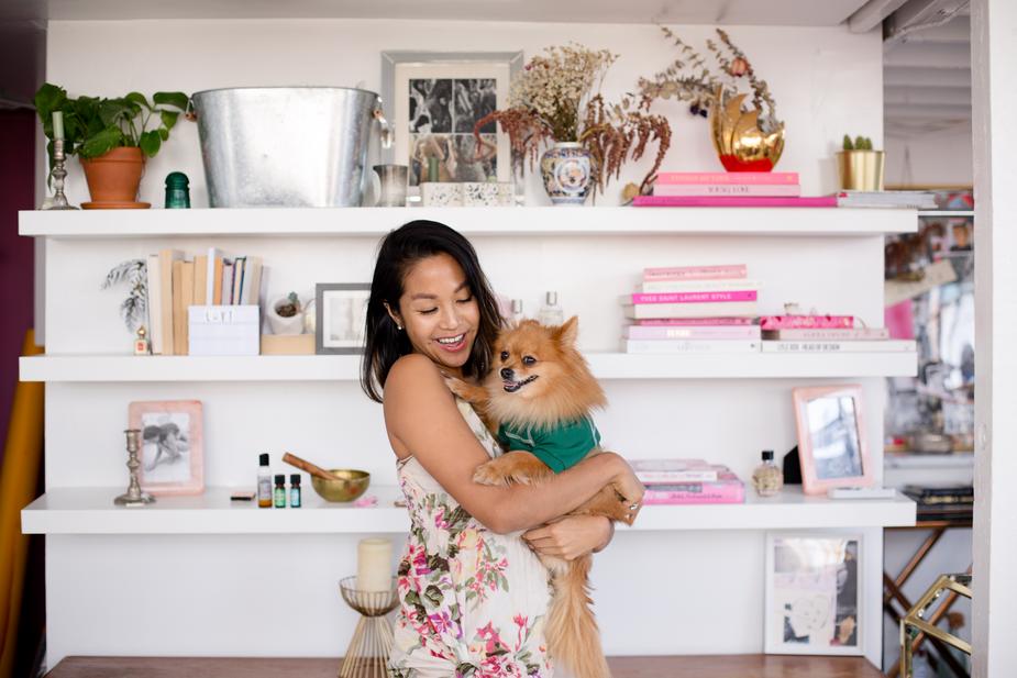 A women smiles and hugs her dog